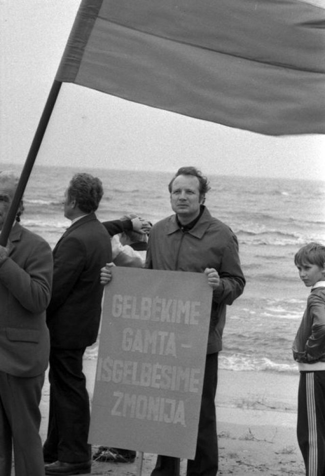 Ekologinės–politinės akcijos „Apjuoskime Baltiją rankomis“ dalyvis, laikantis plakatą „Gelbėkime gamtą – išgelbėsime žmoniją“. 1988 m.